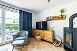 Wohnzimmer mit Fernseher und Sessel - An der Boddenweide - Top-Hundeurlaub