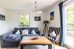Gemütliches Wohnzimmer mit Sofa und Tisch - An der Boddenweide - Top-Hundeurlaub