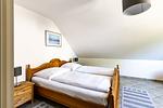 Schlafzimmer mit zwei Betten und Nachttischen - An der Boddenweide - Top-Hundeurlaub