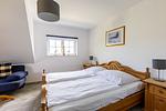 Schlafzimmer mit zwei Betten und Sofa - An der Boddenweide - Top-Hundeurlaub