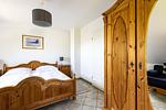 Schlafzimmer mit Doppelbett und Holzschrank - An der Boddenweide - Top-Hundeurlaub