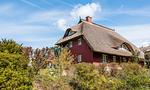 Außenansicht eines Reetdachhauses mit Garten - Strandidyll - Top-Hundeurlaub