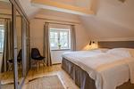 Helles Schlafzimmer mit Doppelbett und Stuhl - Strandhaus Luv - Top-Hundeurlaub