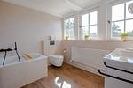 Helles Badezimmer mit Badewanne und Waschbecken - Strandhaus Luv - Top-Hundeurlaub