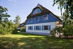 Außenansicht eines großen blauen Hauses mit Reetdach - Wiesenidyll - Top-Hundeurlaub