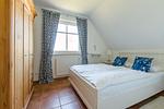 Gemütliches Schlafzimmer mit Doppelbett und Holzschrank - Wiesenidyll - Top-Hundeurlaub