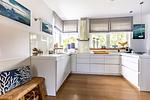 Moderne Küche mit weißen Schränken und Holzfußboden - Freischwimmer - Top-Hundeurlaub