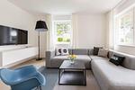 Helles Wohnzimmer mit grauer Couch und Fernseher - Pur A4 - Top-Hundeurlaub