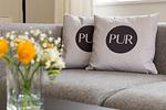 Modernes Wohnzimmer mit grauem Sofa und Kissen - Pur A4 - Top-Hundeurlaub