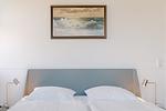 Schlafzimmer mit Doppelbett und beruhigendem Wellenbild - Strandläufer 04 - Top-Hundeurlaub