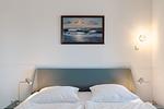 Schlafzimmer mit Doppelbett und Wandkunst - Strandläufer 03 - Top-Hundeurlaub