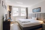 Schlafzimmer mit Bett und Fernseher. - Strandläufer 02 - Top-Hundeurlaub
