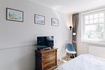 Schlafzimmer mit Fernseher und dekorativen Bildern. - Strandläufer 02 - Top-Hundeurlaub