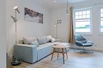 Helles Wohnzimmer mit Sofa, Sessel und Tisch. - Strandläufer 01 - Top-Hundeurlaub