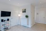 Heller Wohnraum mit TV, Sideboard und dekorativen Elementen. - Strandläufer 01 - Top-Hundeurlaub