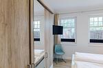 Schlafzimmer mit Doppelbett, Fernseher und Fenster. - Strandläufer 01 - Top-Hundeurlaub