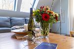 Wohnzimmer mit blåem Sofa und Wein - Strandhaus Wustrow - Wohnung 2 - Top-Hundeurlaub