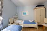 Gemütliches Schlafzimmer mit zwei Betten und Kleiderschrank. - Strandhaus Wustrow - Wohnung 2 - Top-Hundeurlaub