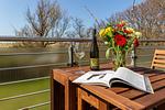 Balkon mit Tisch, Blumen und Blick ins Grüne - Strandhaus Wustrow - Wohnung 3 - Top-Hundeurlaub