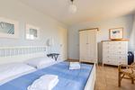 Schlafzimmer mit großem Bett und Kleiderschrank. - Strandhaus Wustrow - Wohnung 1 - Top-Hundeurlaub