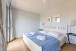 Helles Schlafzimmer mit Doppelbett und Kunstwerken - Strandhaus Wustrow - Wohnung 1 - Top-Hundeurlaub