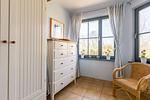 Helles Schlafzimmer mit Kommode und Sessel - Strandhaus Wustrow - Wohnung 1 - Top-Hundeurlaub