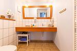 Modernes Badezimmer mit Waschbecken und Spiegel - Strandhaus Wustrow - Wohnung 1 - Top-Hundeurlaub