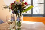 Küchenansicht mit Wasserflaschen und Blumen - Strandhaus Wustrow - Wohnung 5 - Top-Hundeurlaub