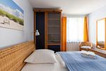 Schlafzimmer mit Rattanbett und Fenster - Strandhaus Wustrow - Wohnung 4 - Top-Hundeurlaub