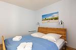 Helles Schlafzimmer mit Doppelbett und Nachttischlampen - Strandhaus Wustrow - Wohnung 4 - Top-Hundeurlaub