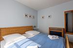 Schlafzimmer mit Doppelbett und Nachttisch - Strandhaus Wustrow - Wohnung 4 - Top-Hundeurlaub