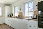 Moderne Küche mit Holzarbeitsplatte und weißen Schränken - Haus Weißdorn - Top-Hundeurlaub