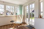 Heller Wohnraum mit Sessel und großen Fenstern - Haus Weißdorn - Top-Hundeurlaub