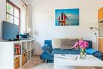 Gemütliches Wohnzimmer mit Sofa und Fernseher - Windrose 09 - Top-Hundeurlaub