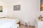 Schlafzimmer mit Bett und weißen Wänden - Windrose 09 - Top-Hundeurlaub