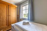 Schlafzimmer mit Bett und Holzschrank - Boddenzauber 01 - Top-Hundeurlaub