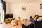 Gemütliches Wohnzimmer mit Sofa und Fernseher - Haus Ostseenixe 01 - Top-Hundeurlaub