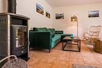 Gemütliches Wohnzimmer mit Sofa und Kamin - Haus Ostseenixe 02 - Top-Hundeurlaub
