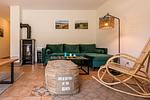 Gemütliches Wohnzimmer mit grüner Couch und Holztisch - Haus Ostseenixe 02 - Top-Hundeurlaub