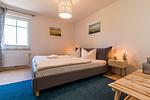 Helles Schlafzimmer mit Doppelbett und Tisch - Haus Ostseenixe 02 - Top-Hundeurlaub