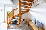 Die Treppe führt in eine helle Halle mit Fliesenboden und Holzregal. - Bootshus - Top-Hundeurlaub