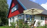 Außenansicht eines rot-weißen Ferienhauses - Bootshus - Top-Hundeurlaub