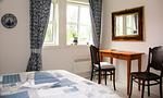 Helles Schlafzimmer mit Bett und Tisch - Bootshus - Top-Hundeurlaub