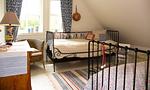 Helles Schlafzimmer mit zwei Betten und Korbsessel - Bootshus - Top-Hundeurlaub