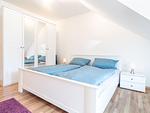 Schlafzimmer mit Doppelbett und TV - Reihenhaus 5b - Seehund - Top-Hundeurlaub