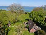 Blick über den eingezäunten Garten  (min. 90 cm) und auf die Flensburger Förde - Strandhaus am Mühlendamm - Top-Hundeurlaub