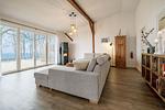 Offenes Wohnzimmer mit Couch, Meerblick, Ofen und Essbereich - Westscheune am Mühlendamm - Top-Hundeurlaub