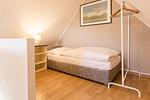 Kompaktes Schlafzimmer mit Bett und Nachttisch - Strandleben 10 - Louis Douzette - Top-Hundeurlaub