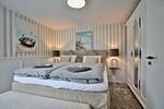 Nautic Lounge – Beach Garden: Schlafzimmer mit Boxspringbett, stilvollem Schrank und maritimen Akzenten in Haffkrug. - Nautic Lounge - Beach Garden - Top-Hundeurlaub