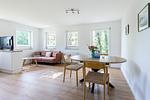 Helles Wohnzimmer mit Sofa und Esstisch - Boddenräuber 1 - Top-Hundeurlaub